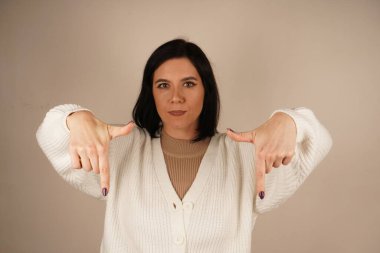 Genç kadın iki işaret parmağıyla tek bir yönü işaret ediyor. Bu da yolu gösteriyor. Duruşu özgüvenli ve anlamlı. Amaç ve berraklıkla dolu bir jest.