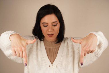 Genç kadın iki işaret parmağıyla tek bir yönü işaret ediyor. Bu da yolu gösteriyor. Duruşu özgüvenli ve anlamlı. Amaç ve berraklıkla dolu bir jest.