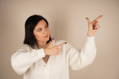 Genç kadın iki işaret parmağıyla tek bir yönü işaret ediyor. Bu da yolu gösteriyor. Duruşu özgüvenli ve anlamlı. Amaç ve berraklıkla dolu bir jest.