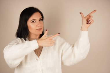 Genç kadın iki işaret parmağıyla tek bir yönü işaret ediyor. Bu da yolu gösteriyor. Duruşu özgüvenli ve anlamlı. Amaç ve berraklıkla dolu bir jest.