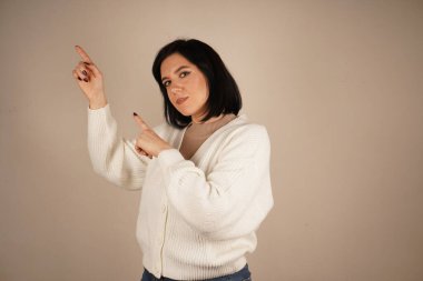 Genç kadın iki işaret parmağıyla tek bir yönü işaret ediyor. Bu da yolu gösteriyor. Duruşu özgüvenli ve anlamlı. Amaç ve berraklıkla dolu bir jest.