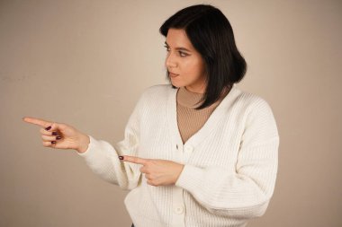 Genç kadın iki işaret parmağıyla tek bir yönü işaret ediyor. Bu da yolu gösteriyor. Duruşu özgüvenli ve anlamlı. Amaç ve berraklıkla dolu bir jest.