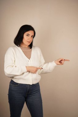 Genç kadın iki işaret parmağıyla tek bir yönü işaret ediyor. Bu da yolu gösteriyor. Duruşu özgüvenli ve anlamlı. Amaç ve berraklıkla dolu bir jest.