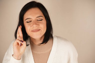 Elleri bir dua jesti ile birbirine kenetlenir, hürmet hissi yayar. Bu poz ruhani bir bağlantıyı yansıtıyor. İnce bir ifade inanç ve umut hissini arttırır.