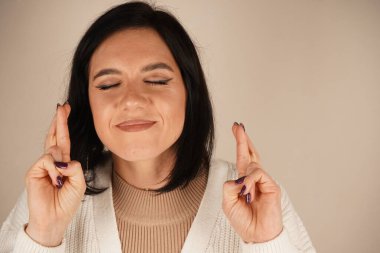 Elleri bir dua jesti ile birbirine kenetlenir, hürmet hissi yayar. Bu poz ruhani bir bağlantıyı yansıtıyor. İnce bir ifade inanç ve umut hissini arttırır.