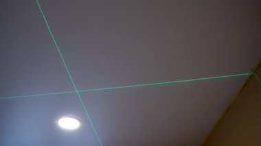 Two bright green laser beams appear one over the other on the floor, ensuring flawless accuracy in the construction process