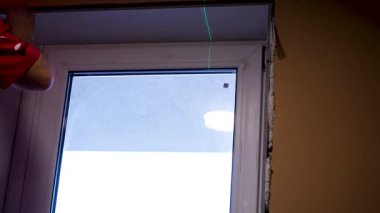 Two bright green laser beams appear one over the other on the floor, ensuring flawless accuracy in the construction process
