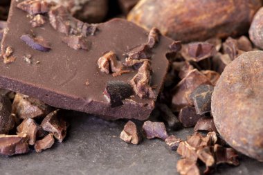 Kahverengi kakao çekirdekli doğal kakao tozu ve eski ahşap bir masa üzerindeki kuru kakao kabuğunun yakın çekimi..