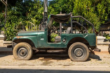 Luang Prabang, Laos - 15 Aralık 2019: Lastikleri patlamış bir Jeep off-road aracı, Laos, Luang Prabang 'da bir caddeye bırakıldı.