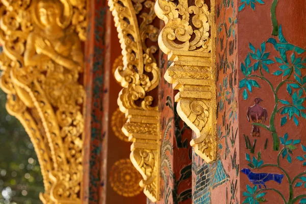 stock image Gilded architectural details richly decorated with reliefs, in the temple Wat Xieng Thong, in Luang Prabang, Laos.