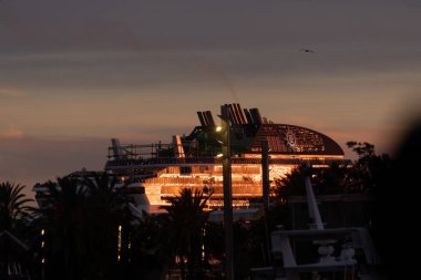 Barselona, İspanya - 08 Ocak 2022: Bir MSC yolcu gemisi gün batımından önce Barcelona limanına yanaştı, güneş ışığının son ışınlarını gece karanlığından önce yansıttı