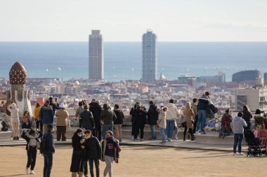 Barselona, İspanya - 09 Ocak 2022: İnsanlar, turistler, uzaktaki Barselona şehri ve Akdeniz manzarasının tadını çıkarıyorlar.