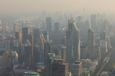 Bangkok, Tayland 'ın gökdelenleriyle gün batımında Baiyoke Kulesi 2' nin gözlem güvertesinden kirliliğe gömülmüş gökdelenlerin panoramik görüntüsü