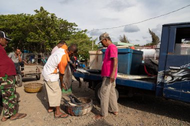 Pulau Weh, Endonezya - 1 Ağustos 2019: Endonezya 'nın Banda Aceh kenti yakınlarındaki bir limanda günün balık avı pazarlığı yapan çok sayıda adam
