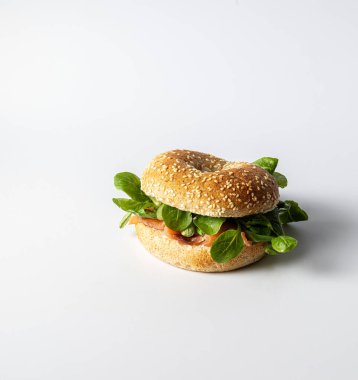 Somon ve yeşil kuzu salatasıyla kaplanmış susamlı lezzetli bir simit.