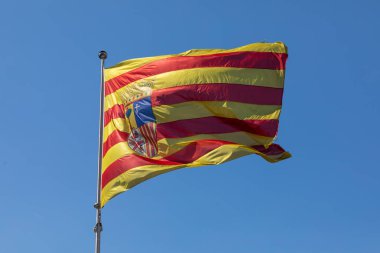 Aragon Topluluğunun bayrağı, İspanya 'nın Zaragoza kentindeki Plaza de Aragon' da rüzgarda sallanıyor.