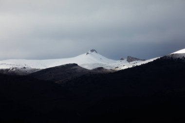 Moncayo doğal parkı yakınlarındaki dağların manzarası, kışın karla kaplı, soğuk gri bir gökyüzünün altında, Aragon, İspanya