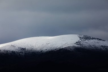 Moncayo doğal parkı yakınlarındaki dağların manzarası, kışın karla kaplı, soğuk gri bir gökyüzünün altında, Aragon, İspanya