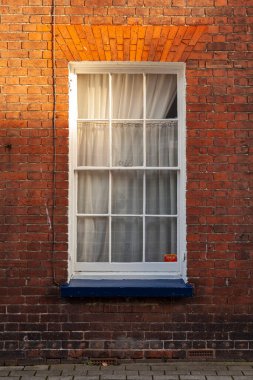 Beyaz pencereli, perdeli, kırmızı tuğlalı duvarlı, tipik bir İngiltere, Canterbury.