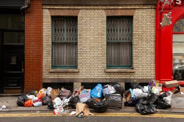 London, UK - sep 22, 2013: Several bags and boxes of rubbish thrown away uncollected on a street in central London clipart