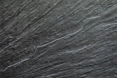 Bir binanın ön cephesinde zarif, koyu gri bir yazı tahtası üzerinde soyut çizgiler.