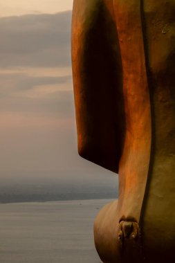 Wat Phousalao Tapınağı 'nda, Pakse, Champasak, Laos yakınlarındaki meditasyon pozisyonunda oturan Buda' nın büyük altın heykelinin yakın çekimi.