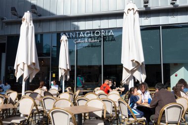 Zaragoza, İspanya - 30 Nisan 2025: Puerto Venecia 'daki Santagloria pastanesinde sandalyeli ve müşterili teras