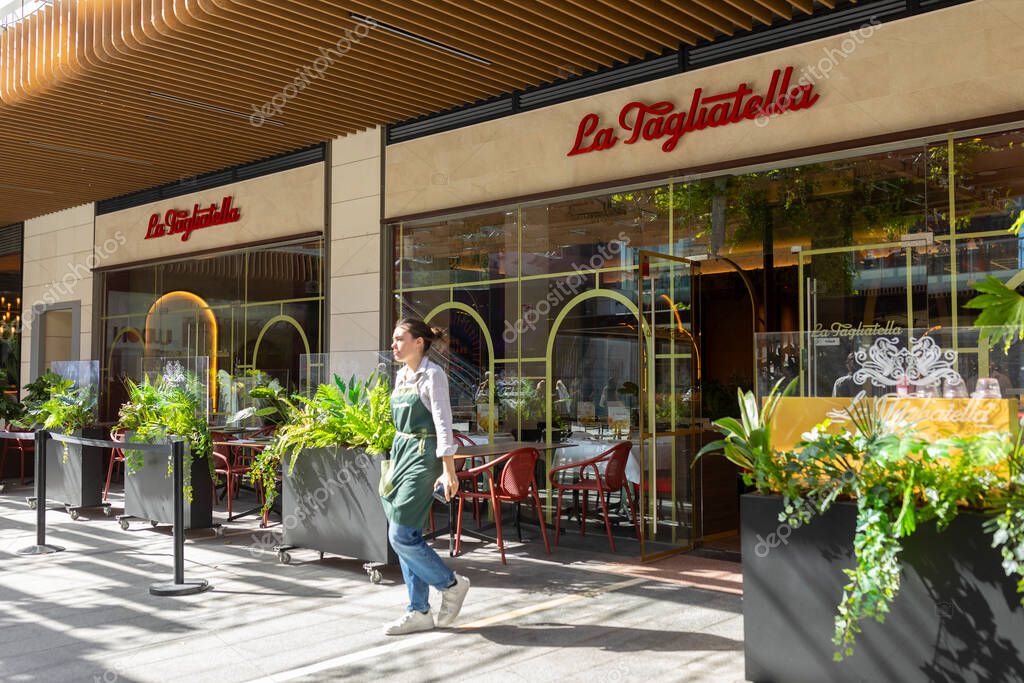 Zaragoza, Spain - 30 april, 2025: A waitress leaves the Italian food restaurant of the La Tagliatella chain, in Puerto Venecia