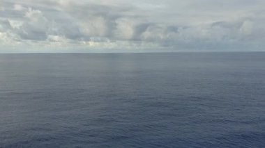 Okyanus manzarası ve gökyüzündeki bulutlar. Okyanus üzerinde güneşli havada bulutlu mavi gökyüzü. Ufuktaki dağlar ve okyanus. Yüksek kalite 4k görüntü