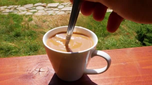 Young Man Stirs Sugar Cup Coffee While Standing Porch His — Stock Video