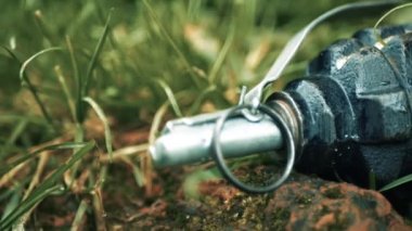 Çimenlerin üzerinde bir el bombası var. Sinsi bir anti-personel el bombası çimlerin arasına gizlenmiş. Yüksek kalite 4k görüntü