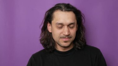 Çekici bir gencin yakın plan portresi, gülüyor ve baş parmağını kaldırıyor. Yüksek kalite 4k görüntü