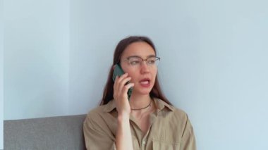 Genç ve çekici bir kız erkek arkadaşıyla cep telefonunda konuşuyor. Yüksek kaliteli FullHD görüntüler