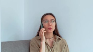 Genç ve çekici bir kız erkek arkadaşıyla cep telefonunda konuşuyor. Yüksek kaliteli FullHD görüntüler