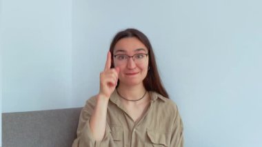 Genç ve çekici bir kız parmağını kaldırarak onu linke tıklamaya davet ediyor. Yüksek kalite 4k görüntü