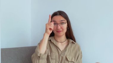 Genç ve çekici bir kız parmağını kaldırarak onu linke tıklamaya davet ediyor. Yüksek kalite 4k görüntü