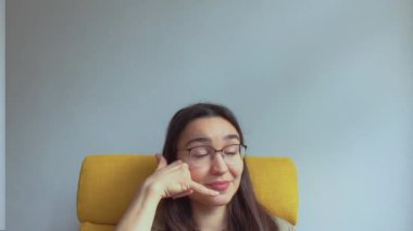  Genç, çekici bir kız elini kulağına koyar ve onu geri aramak için bir işaret yapar. Yüksek kaliteli FullHD görüntüler