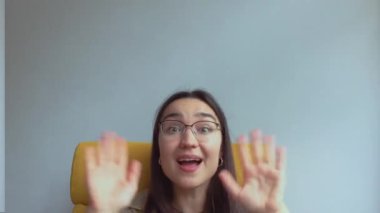 Genç ve çekici bir kız arkadaşlarını selamlamak için elini sallıyor. Yüksek kalite FullHD görüntüler.