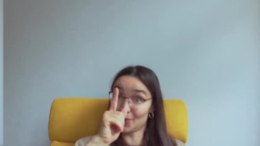  Genç, çekici bir kız elini kulağına koyar ve onu geri aramak için bir işaret yapar. Yüksek kaliteli FullHD görüntüler