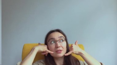  Genç, çekici bir kız elini kulağına koyar ve onu geri aramak için bir işaret yapar. Yüksek kaliteli FullHD görüntüler