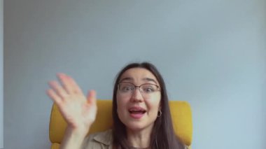 Genç ve çekici bir kız arkadaşlarını selamlamak için elini sallıyor. Yüksek kalite FullHD görüntüler.