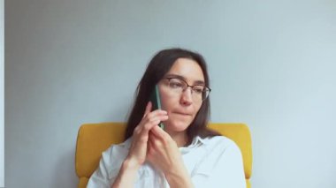 Genç ve çekici bir kız erkek arkadaşıyla cep telefonunda konuşuyor. Yüksek kaliteli FullHD görüntüler