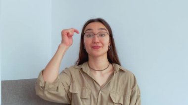 Genç ve çekici bir kız parmağını aşağı indirip onu bağlantıyı takip etmeye davet ediyor. Yüksek kalite 4k görüntü