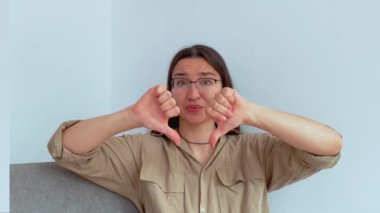Genç ve çekici bir kız hayal kırıklığıyla baş parmağını kaldırıyor. Yüksek kalite 4k görüntü