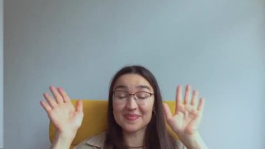 Genç ve çekici bir kız arkadaşlarını selamlamak için elini sallıyor. Yüksek kalite FullHD görüntüler.