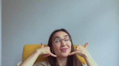  Genç, çekici bir kız elini kulağına koyar ve onu geri aramak için bir işaret yapar. Yüksek kaliteli FullHD görüntüler