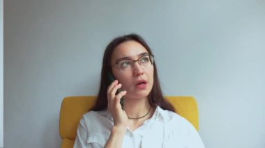 Genç ve çekici bir kız erkek arkadaşıyla cep telefonunda konuşuyor. Yüksek kaliteli FullHD görüntüler