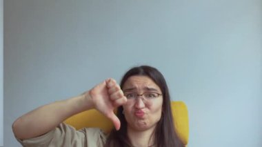 Genç ve çekici bir kız hayal kırıklığıyla baş parmağını kaldırıyor. Yüksek kalite 4k görüntü