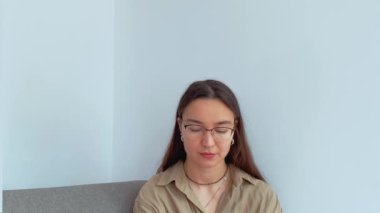 Kulaklıklı genç ve çekici bir kız telefonda konuşuyor ve online danışmanlık yapıyor. - Evet. Yüksek kalite 4k görüntü