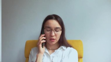 Genç ve çekici bir kız erkek arkadaşıyla cep telefonunda konuşuyor. Yüksek kaliteli FullHD görüntüler